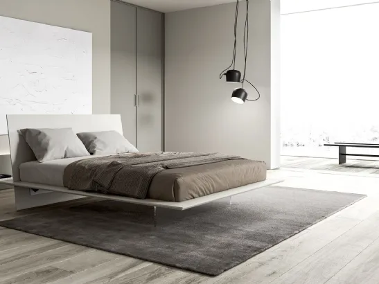 Letto liscio ed essenziale dove base e testiera si intersecano definendo una struttura minimal Plana di Presotto